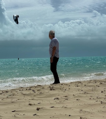 The author is seen standing on Long Bay beach in the Turks and Caicos watching a single kitesurfer on the sea