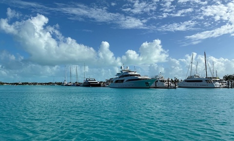 A fleet of modern luxury yachts and motorboats are docked along Blue Haven Marina's wooden piers